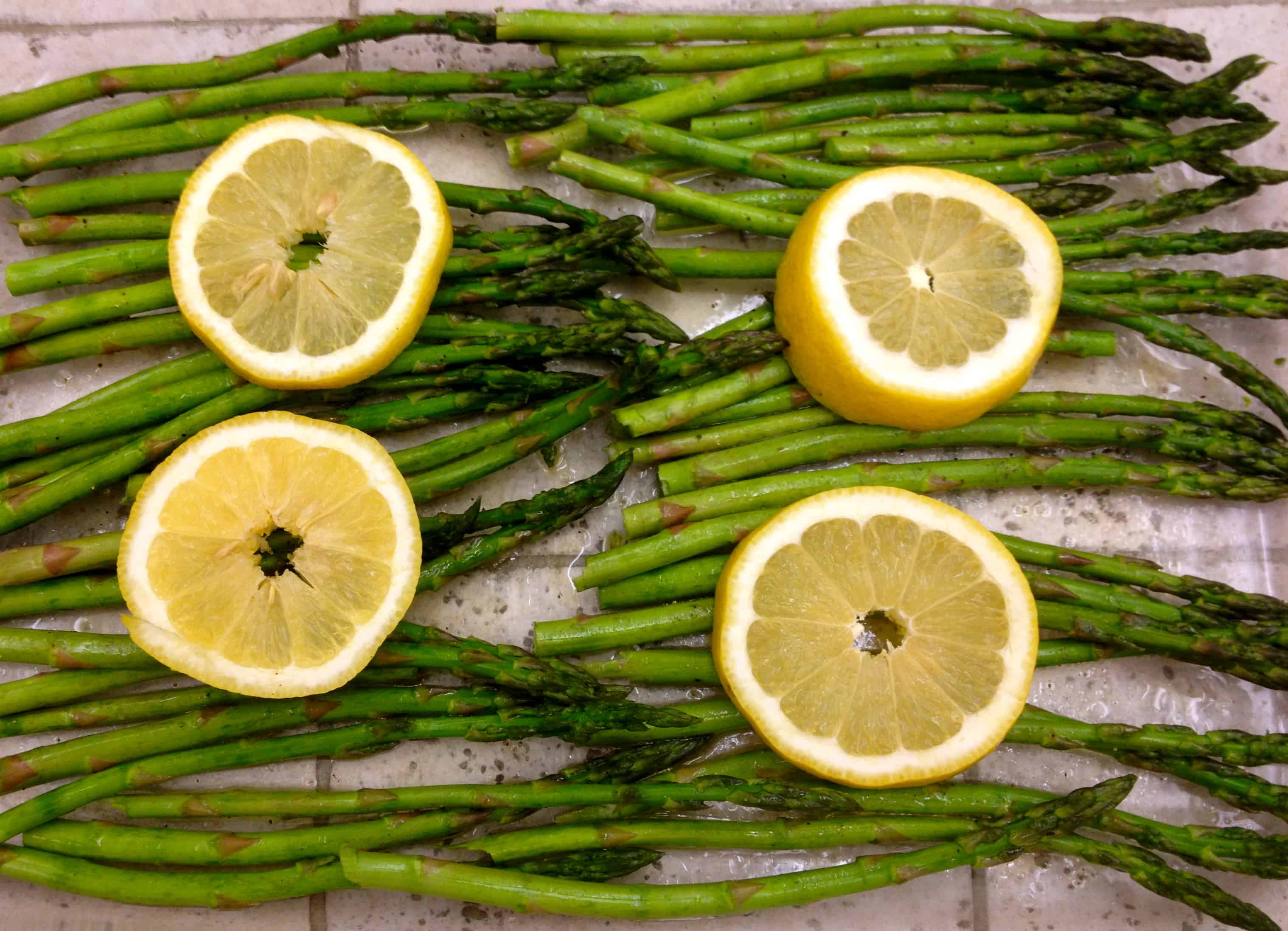 asparagus and lemon on a baking sheet
