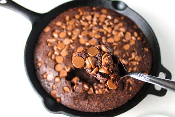 spooning the brownie out of the skillet