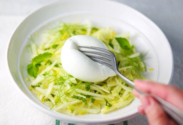 cutting burrata with a fork