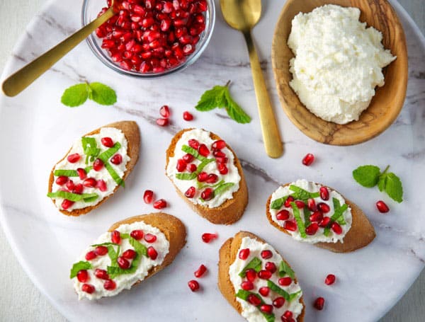 This Pomegranate Crostini with Ricotta and Mint will be your new favorite appetizer! It's super easy to make for any last minutes guests, and is sure to wow a crowd!