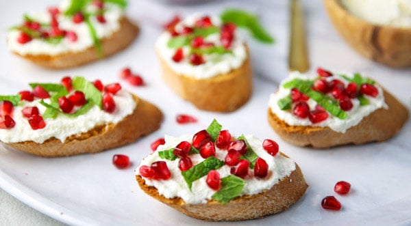 This Pomegranate Crostini with Ricotta and Mint will be your new favorite appetizer! It's super easy to make for any last minutes guests, and is sure to wow a crowd!