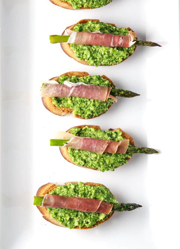 These Prosciutto Wrapped Asparagus with Lemon Pesto Crostini are a great appetizer to throw together at the last minute. This is a hit at every party! #appetizer #glutenfree #prosciutto #asparagus #easyrecipes