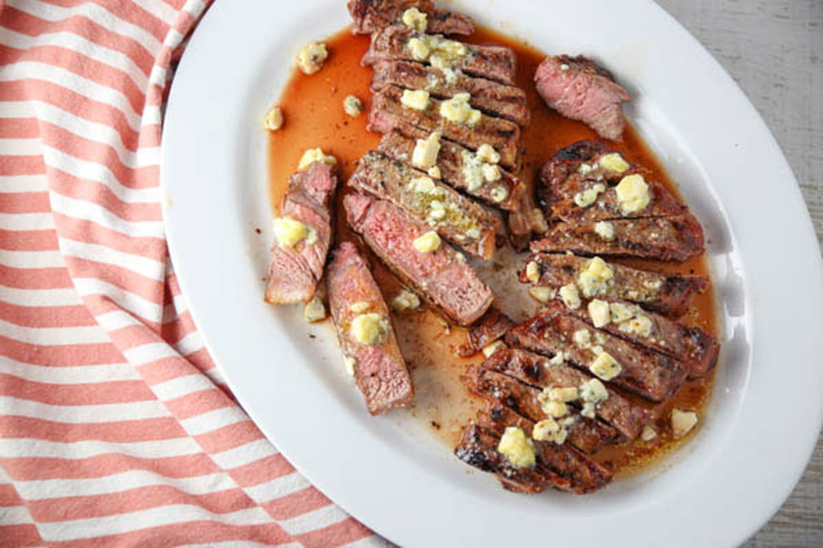 New York strip steak with blue cheese butter on a platter