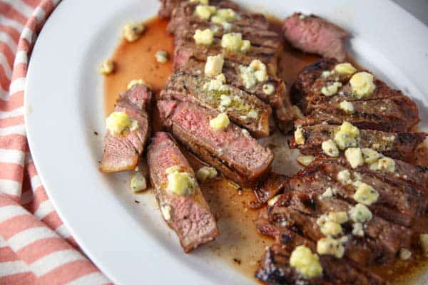 New York Strip Steaks cut into pieces with Blue Cheese Butter on top