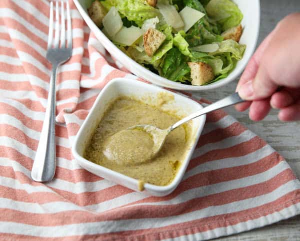 Homemade Caesar Salad Dressing in a bowl with a spoon