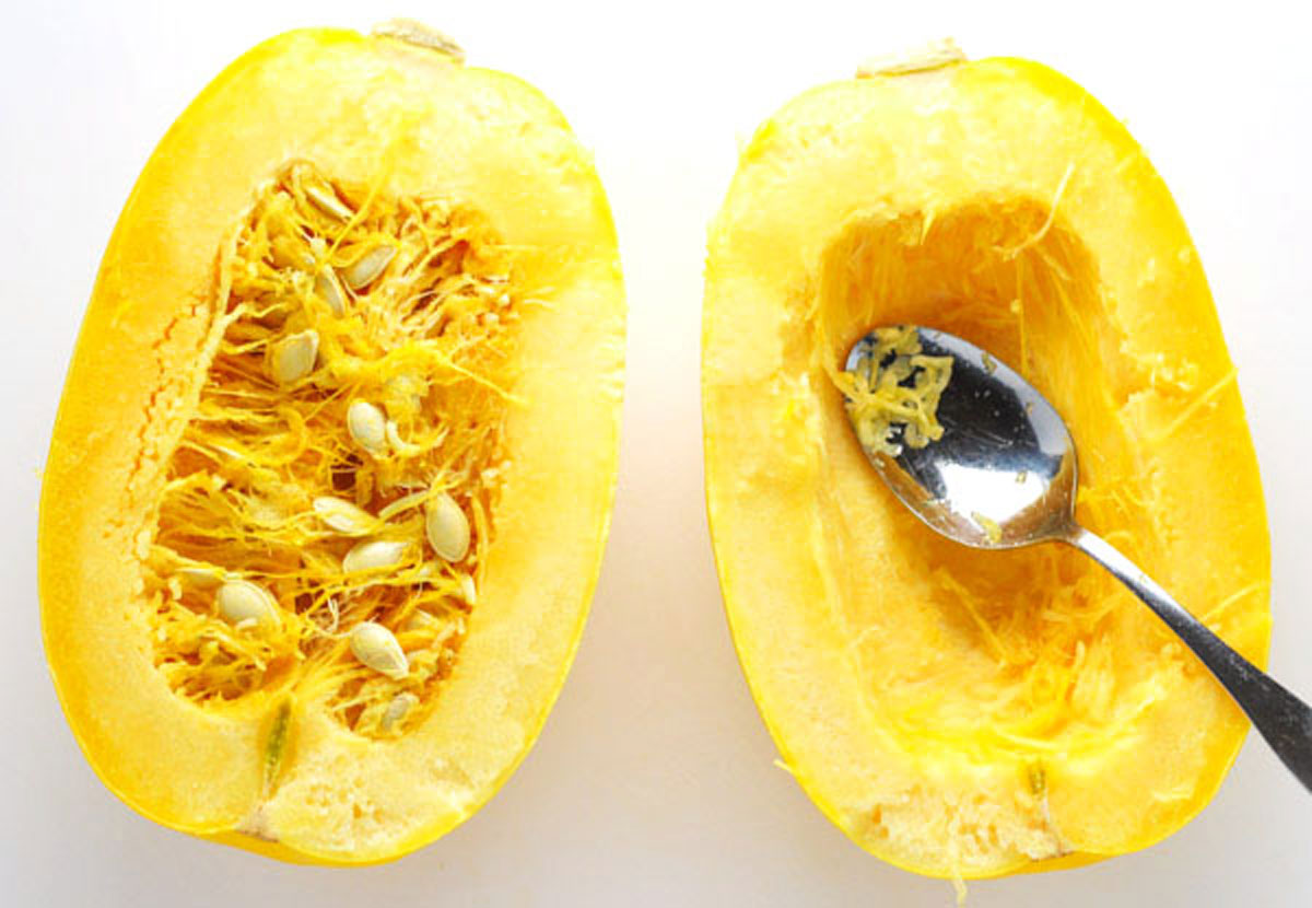 scooping out seeds from spaghetti squash