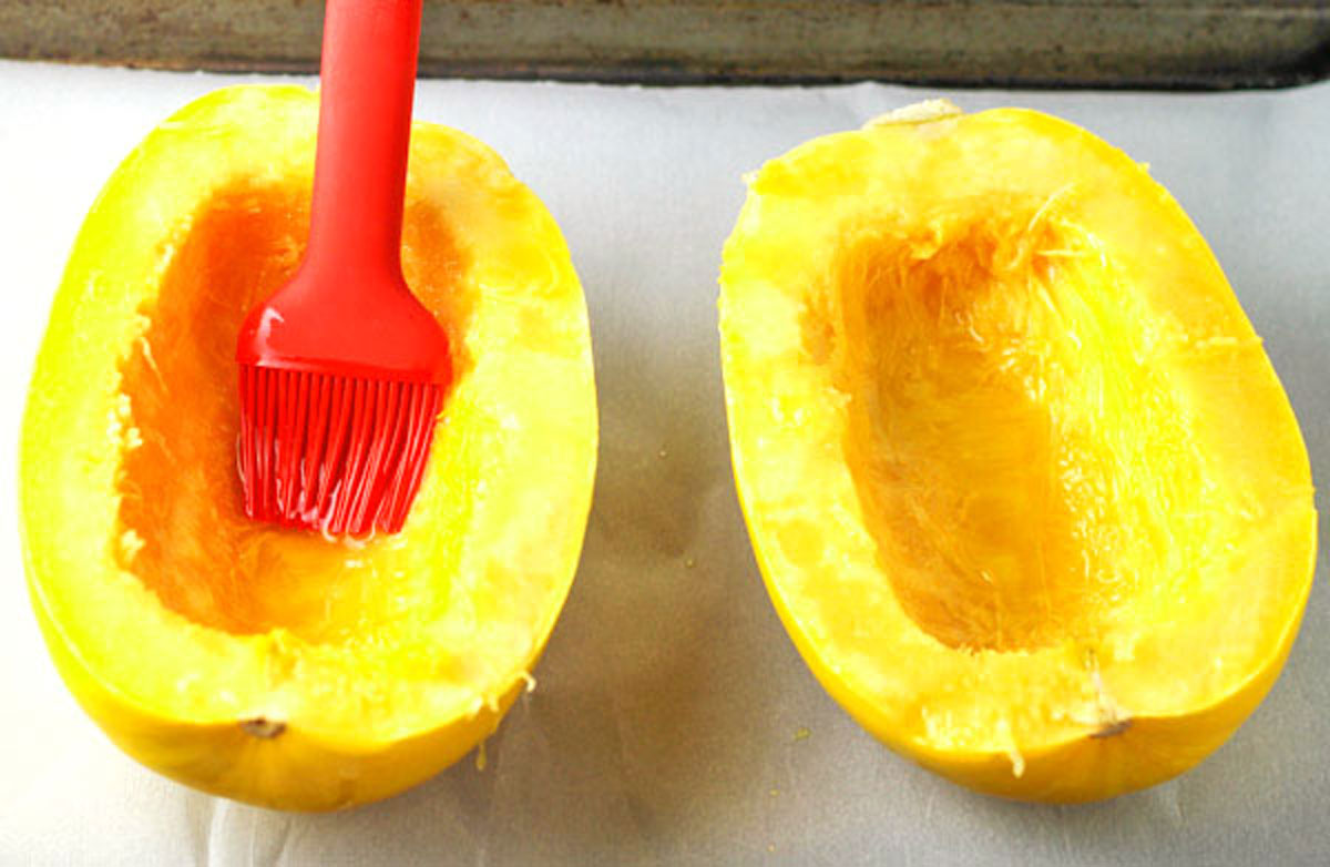 brushing inside of spaghetti squash with olive oil