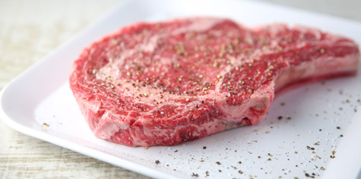 ribeye steak with salt and pepper on a plate