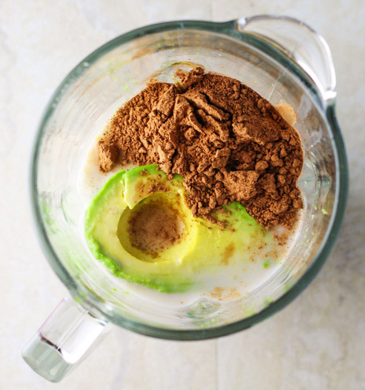 avocado, cacao power, almond milk, banana and honey in a blender