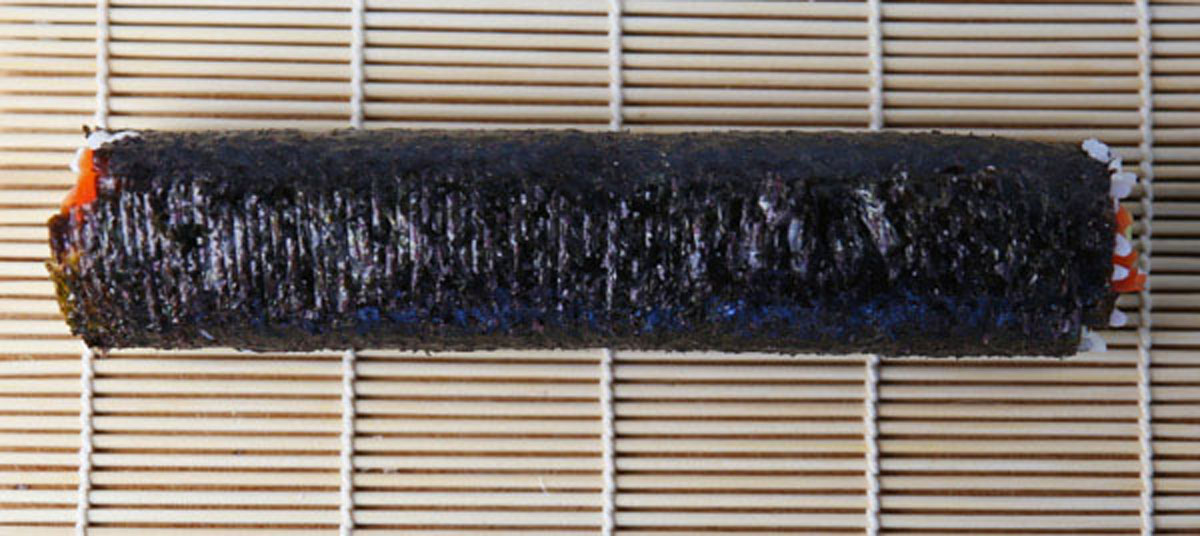 smoked salmon sushi roll on a sushi mat