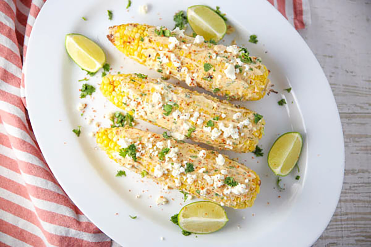 Grilled Mexican Street Corn with limes on a platter