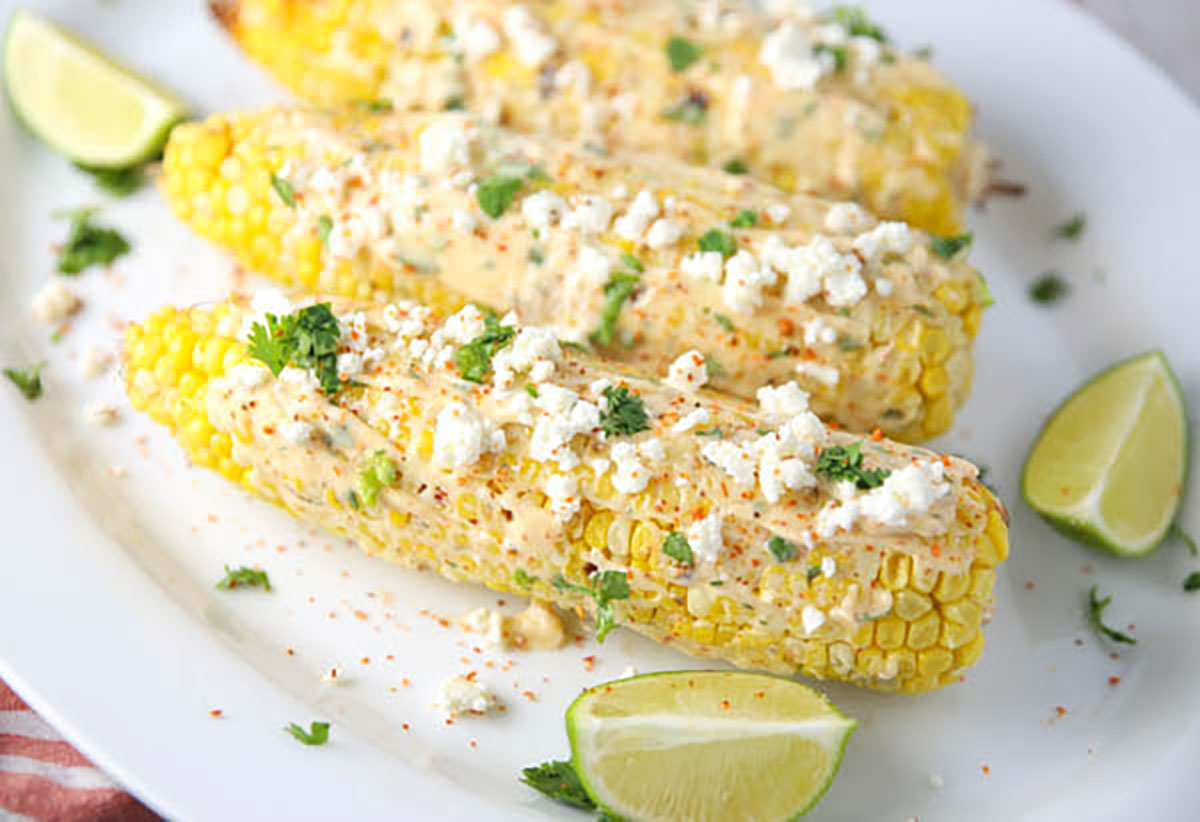 Grilled Mexican Street Corn on a plate with limes