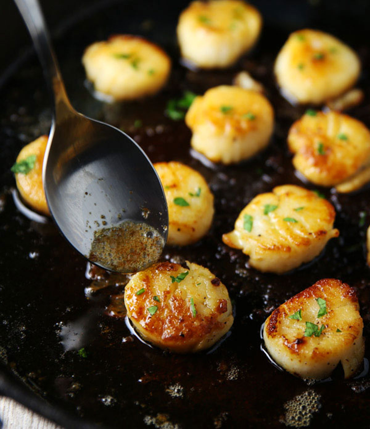 Spooning butter over scallops